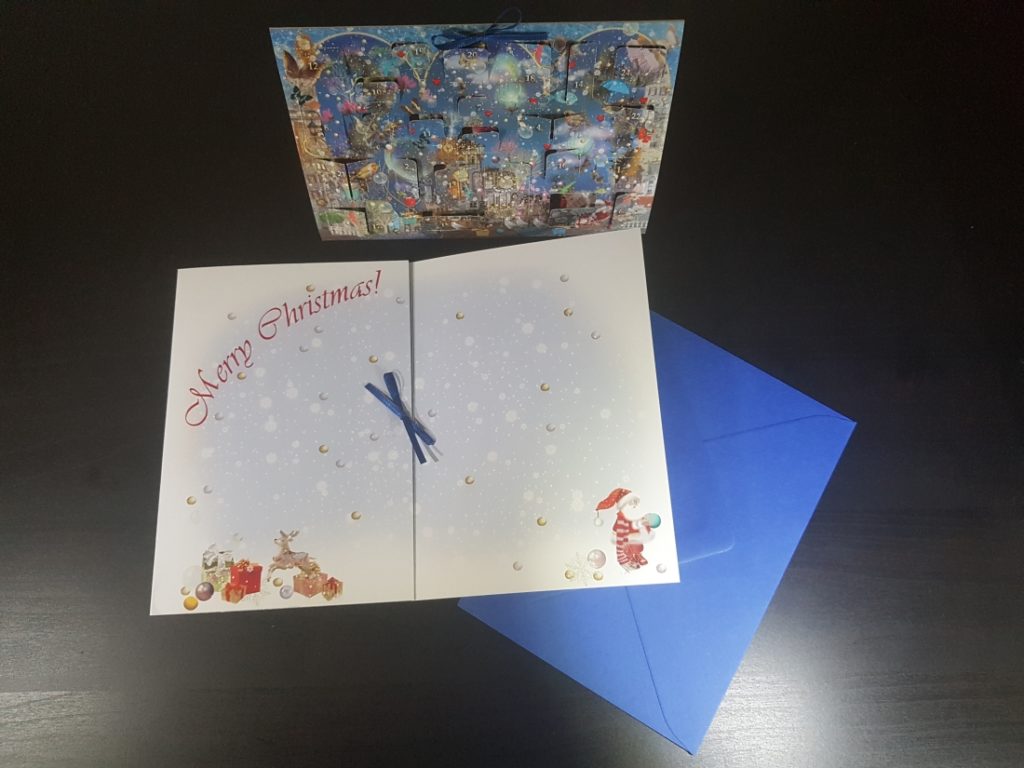 aufgeklappter Adventskalender mit der Inschrift "Merry Christmas"